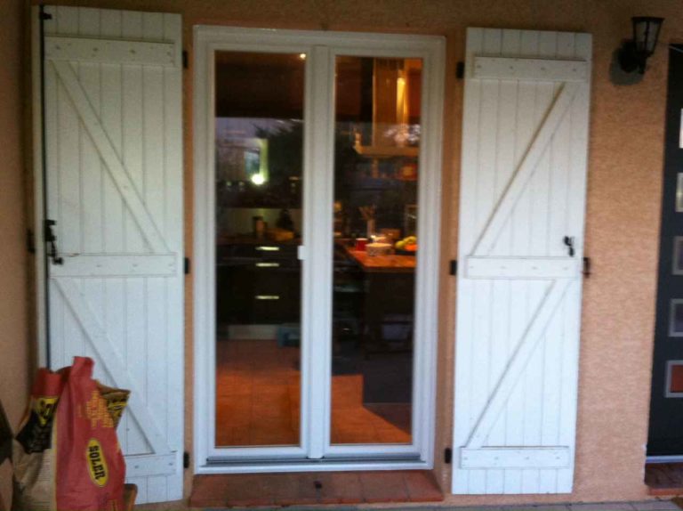 Porte-fenêtre blanche et volets battants blancs