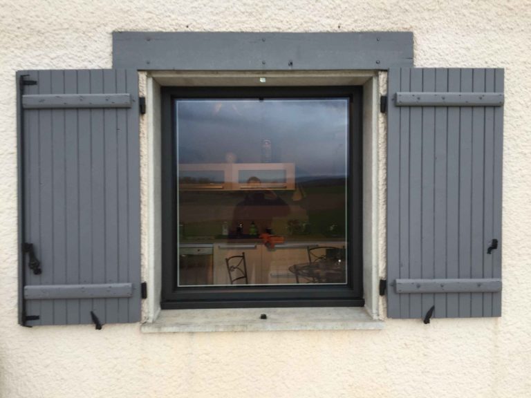 Fenêtre anthracite et volets gris sur façade enduite