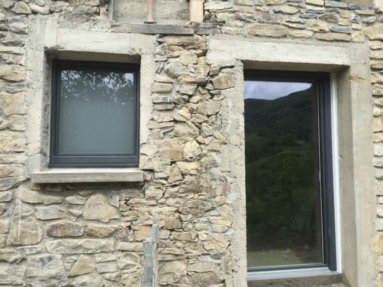Fenêtres anthracite sur une façade en pierre en rénovation