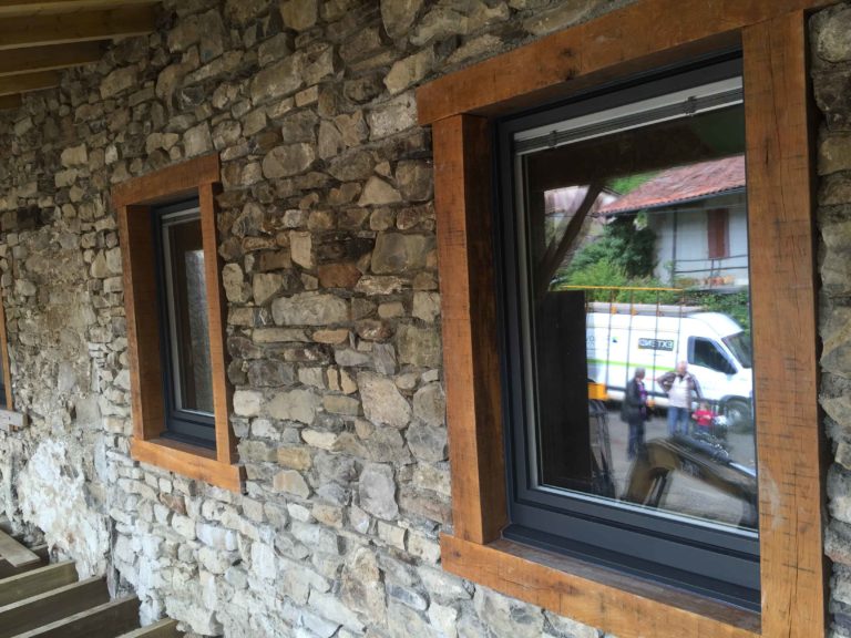 Fenêtre anthracite et encadrement bois sur mur en pierre