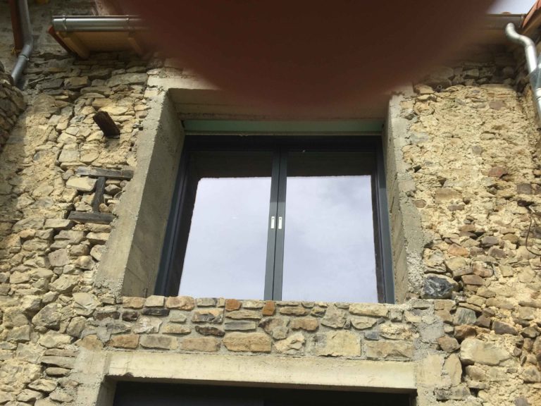 Fenêtre anthracite posée dans un mur en pierre
