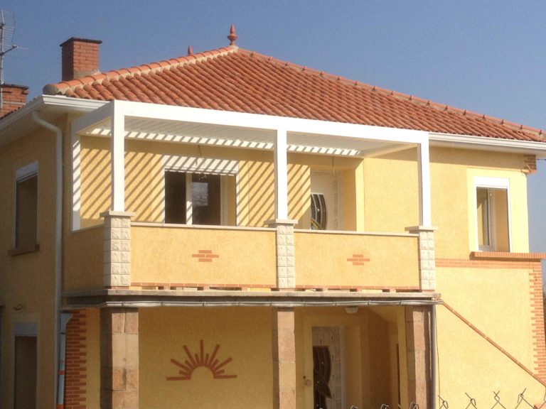 Pergola blanche à l'étage d'une maison à façade jaune