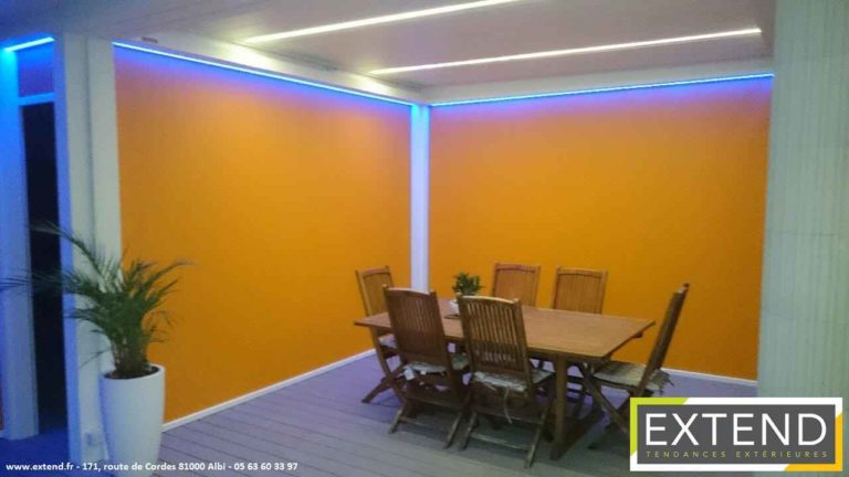 Coin repas sous pergola avec screens orange et LED bleues