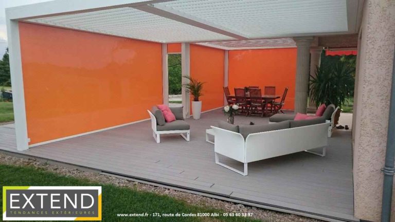 Pergola avec screens orange baissés autour d'un salon de jardin