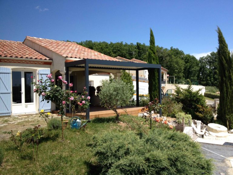 Pergola anthracite au milieu d'un jardin fleuri