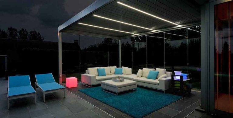 Pergola éclairée par LED intégrées au-dessus d'un salon lounge, de nuit