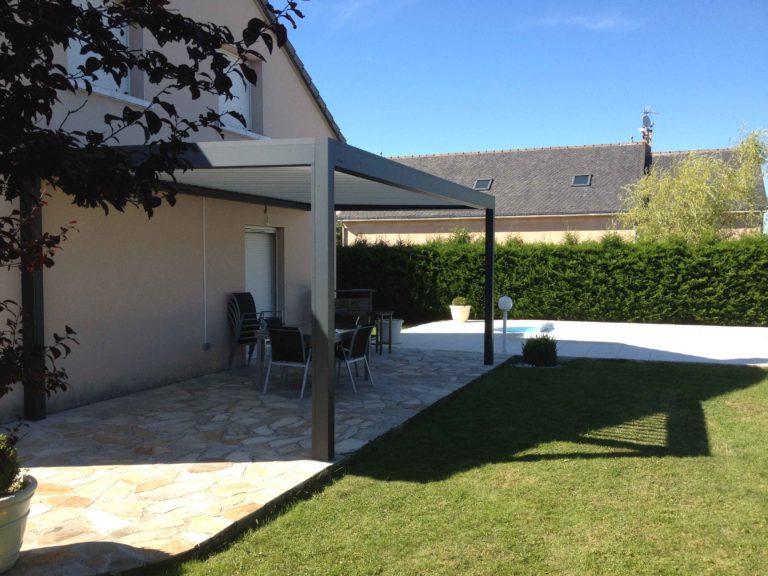Pergola anthracite sur terrasse pavée en bord de jardin