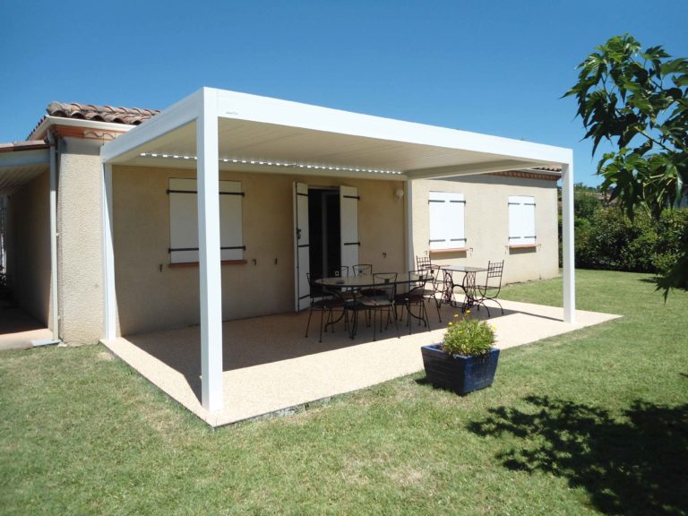 Pergola bioclimatique blanche devant une maison de plain-pied