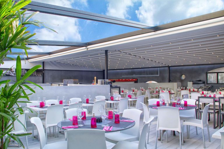 Grande pergola à toile sur la terrasse d'un restaurant dressé pour une réception