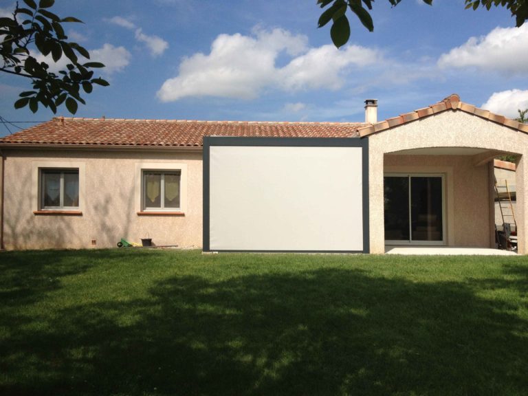 Pergola avec screen baissé devant une maison de plain-pied