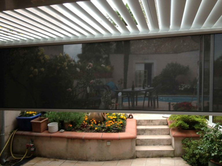 Screen baissé sous une pergola blanche, vue de l'intérieur