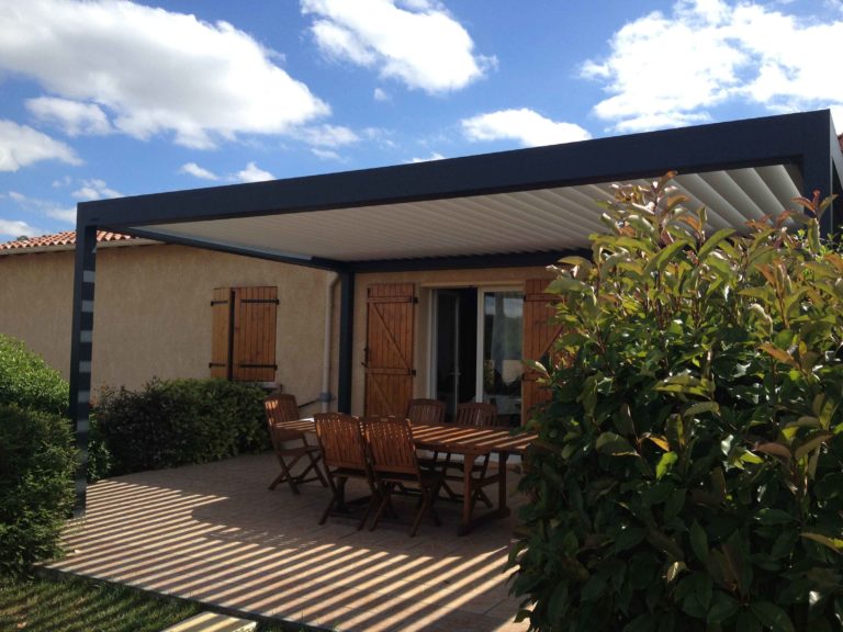 Pergola anthracite et terrasse en bois sous un ciel bleu