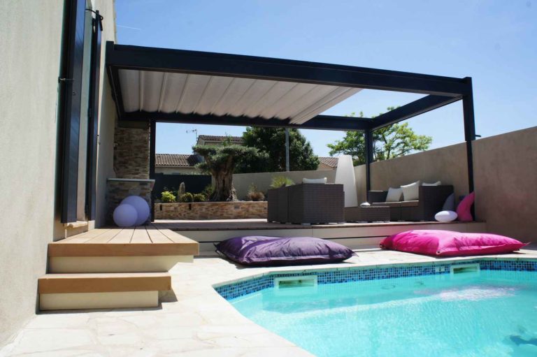 Pergola anthracite au bord d'une piscine, coussins colorés