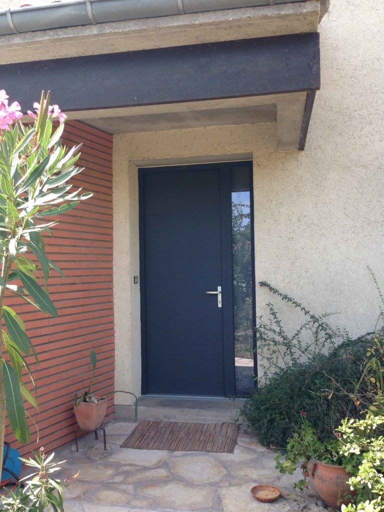 Porte d'entrée anthracite sous auvent, entrée fleurie