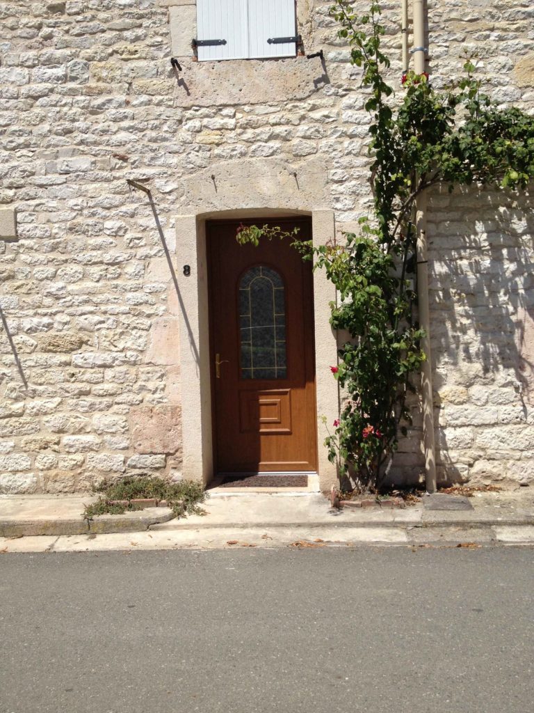 Porte d'entrée bois sur une maison en pierre