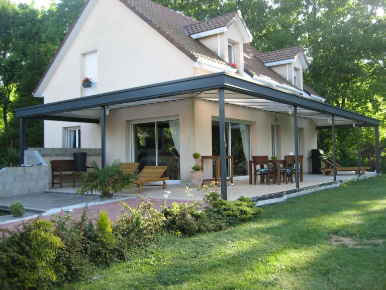 Couverture de terrasse et massif fleuri devant une maison
