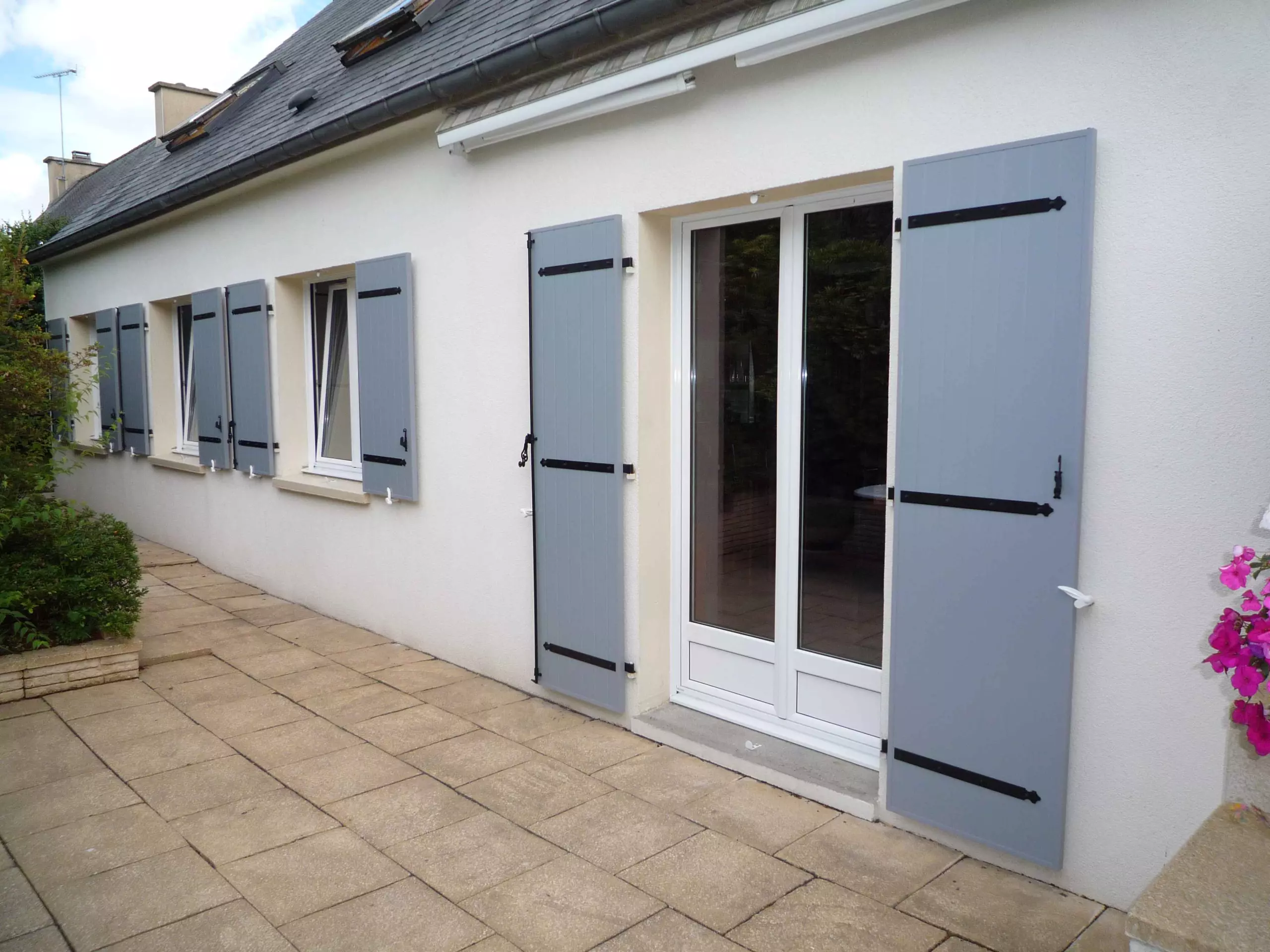 Volets battants gris posés par EXTEND sur une maison de plain-pied