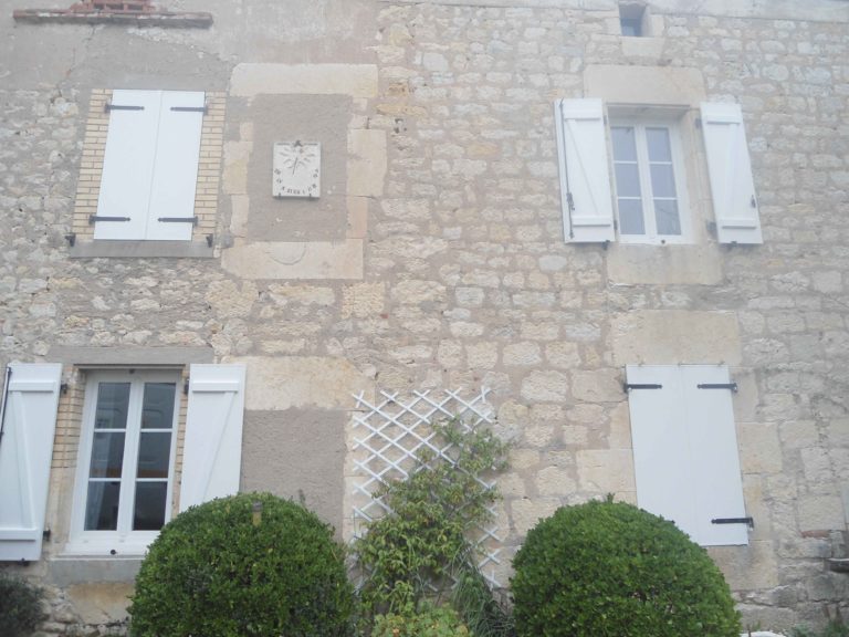 Façade en pierre avec volets blancs