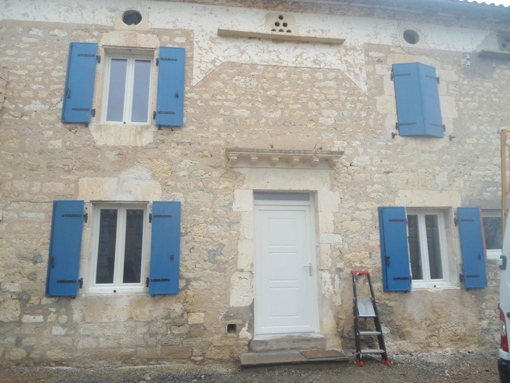 Façade en pierre avec volets bleus, réalisation EXTEND