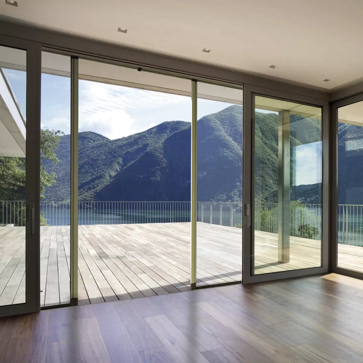 Grande baie vitrée ouverte sur une terrasse avec vue sur les montagnes