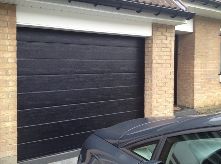 Porte de garage sectionnelle rainurée aspect bois veiné, photo La Toulousaine