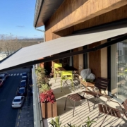 Store banne B25 ouvert, offrant de l'ombre sur un balcon.