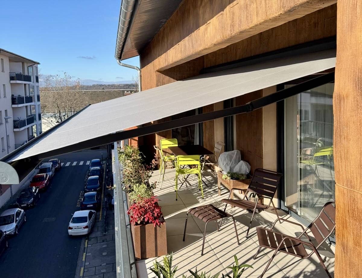 Store banne Brustor B25 posé par EXTEND au-dessus d’un balcon