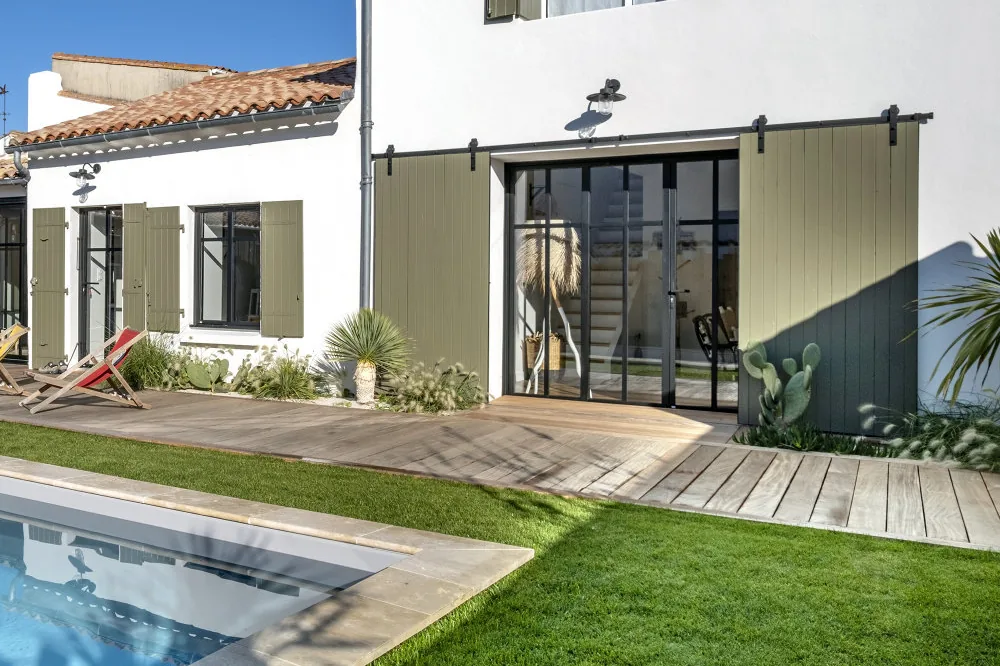 Baies coulissantes aluminium noires ouvertes sur une piscine