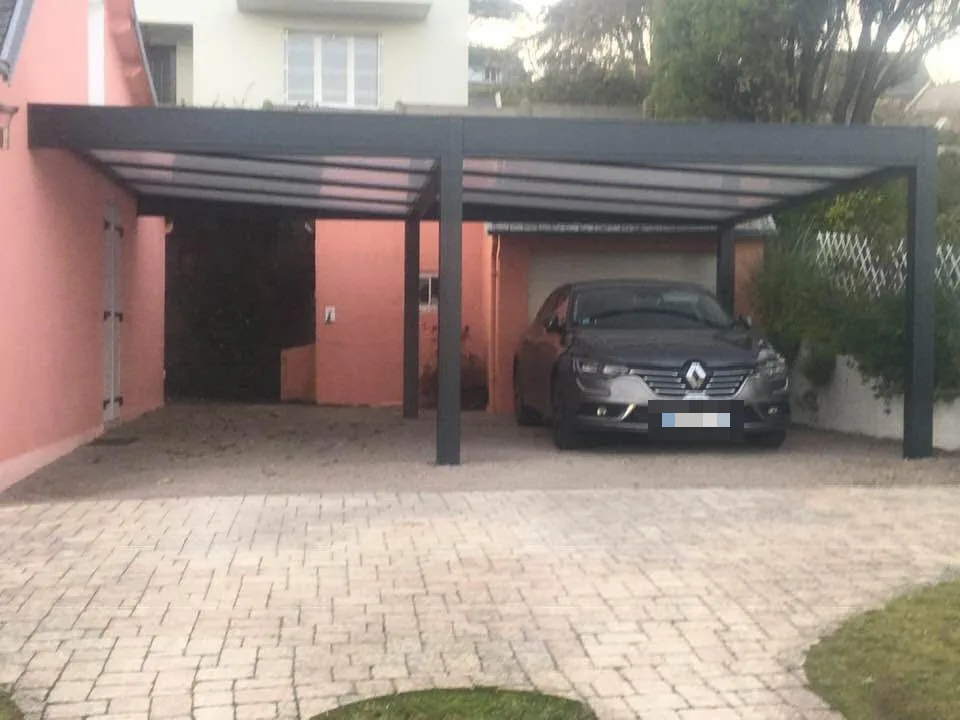 Carport en aluminium adossé à une maison, posé par EXTEND, une voiture garée dessous