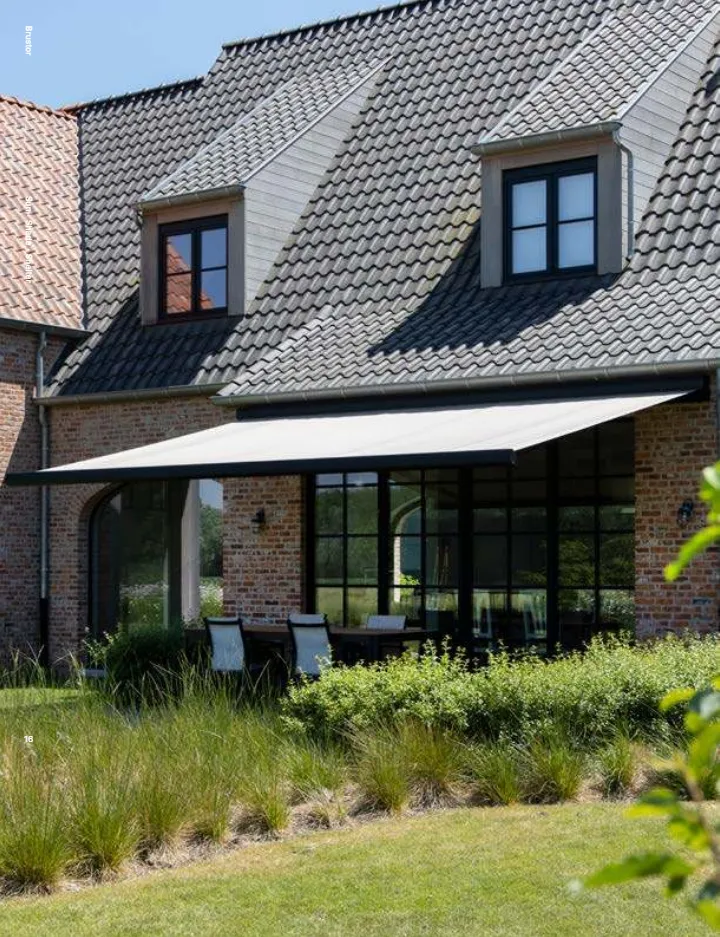 Store banne Brustor déroulé devant une maison en brique