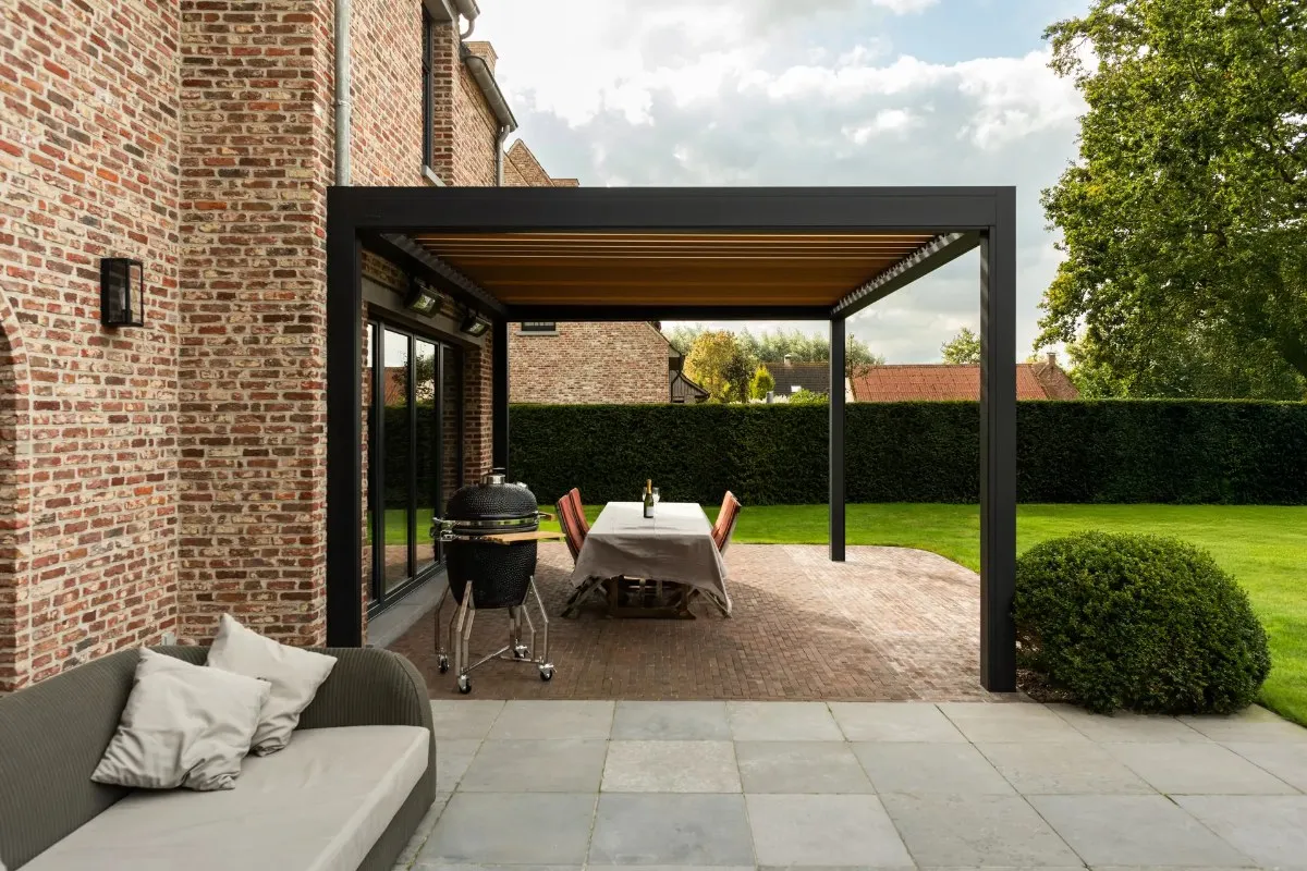 Pergola Brustor anthracite sur une terrasse de jardin