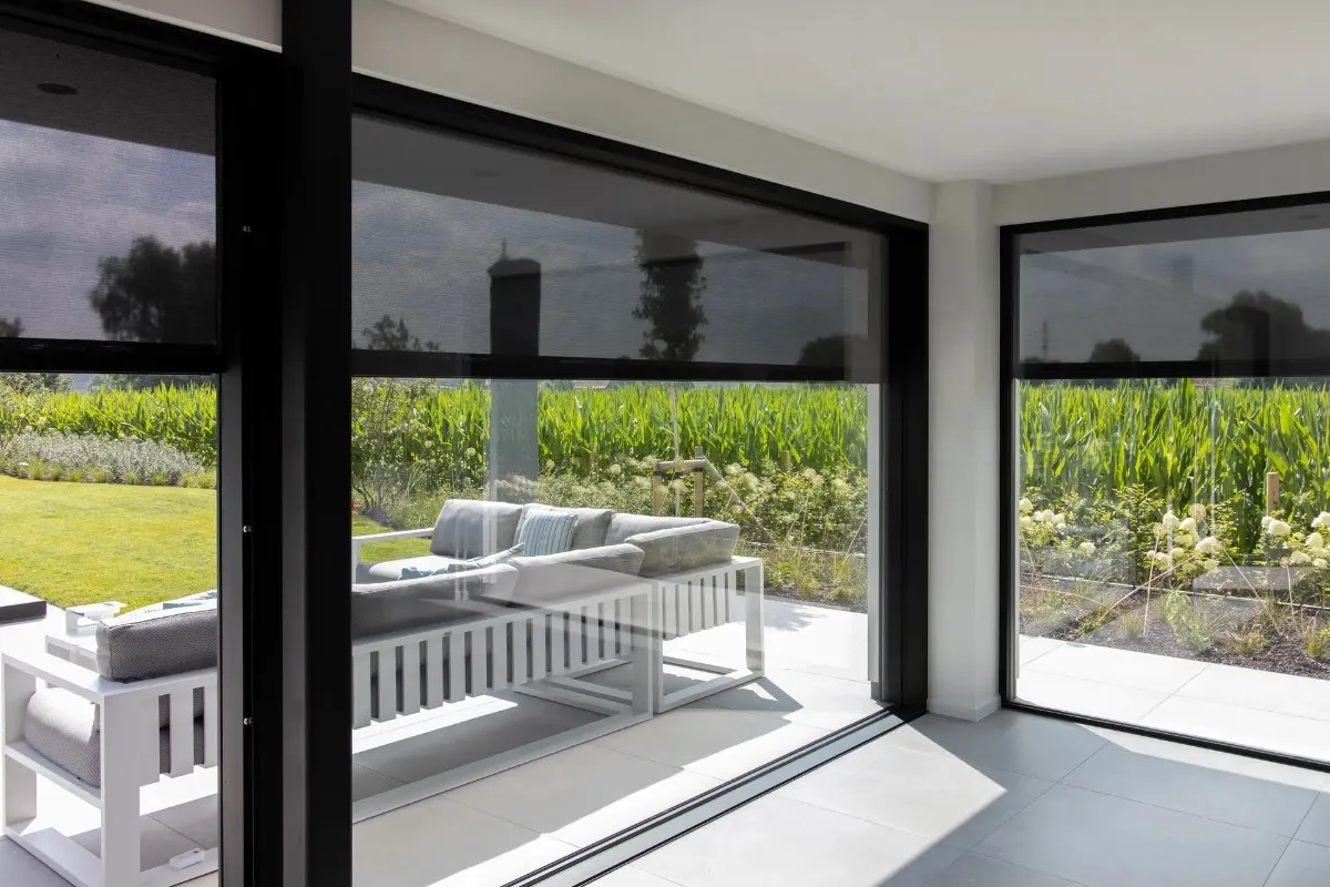 Vue sur le jardin depuis l'intérieur, stores verticaux baissés