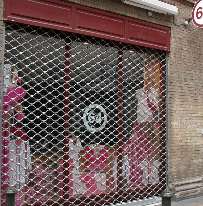 Grille de protection ajourée devant une vitrine de commerce
