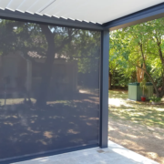 Store vertical déroulé sous une pergola bioclimatique, vue de l’intérieur