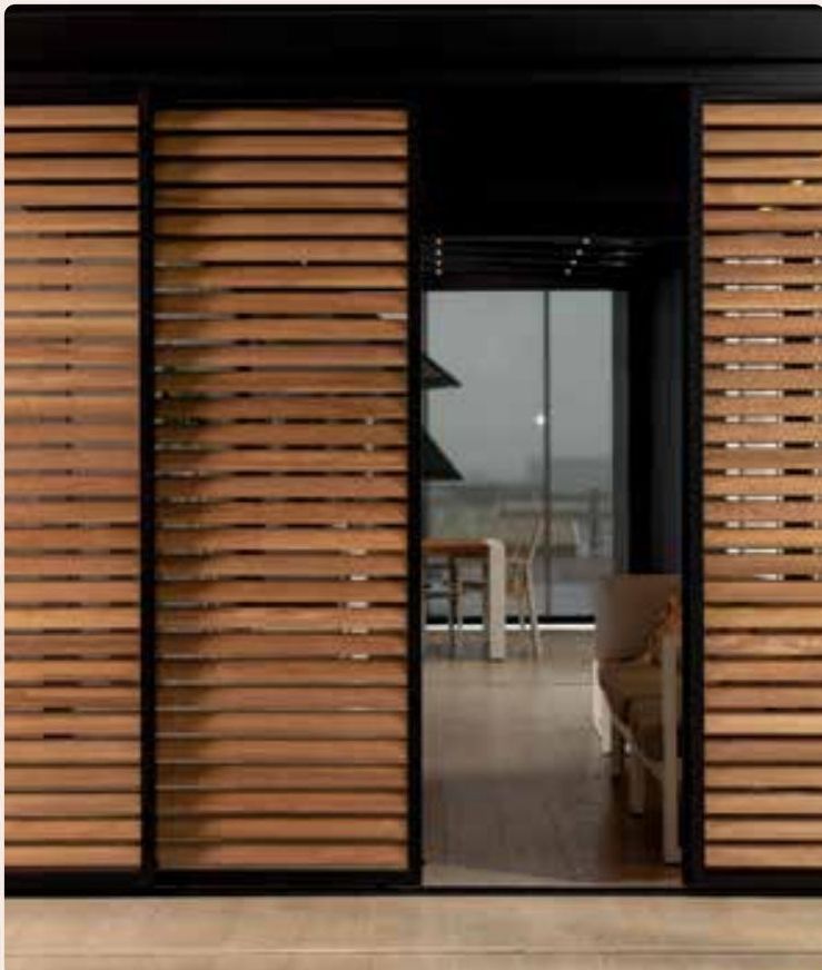 Paroi coulissante Brustor en lames de bois, porte vitrée derrière