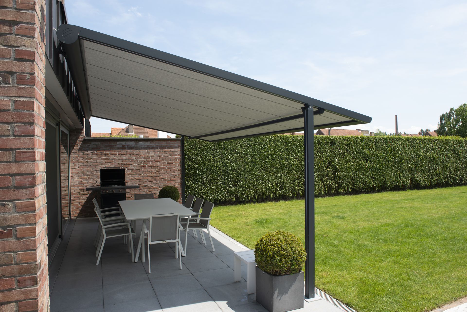 Pergola Brustor B128 adossée à une façade en brique