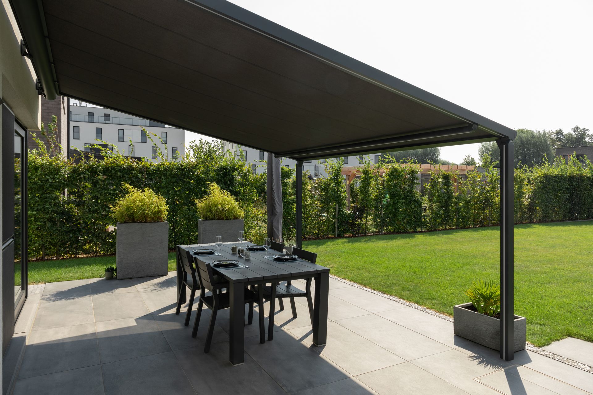 Pergola Brustor B128 au-dessus d'une table de repas dans un jardin