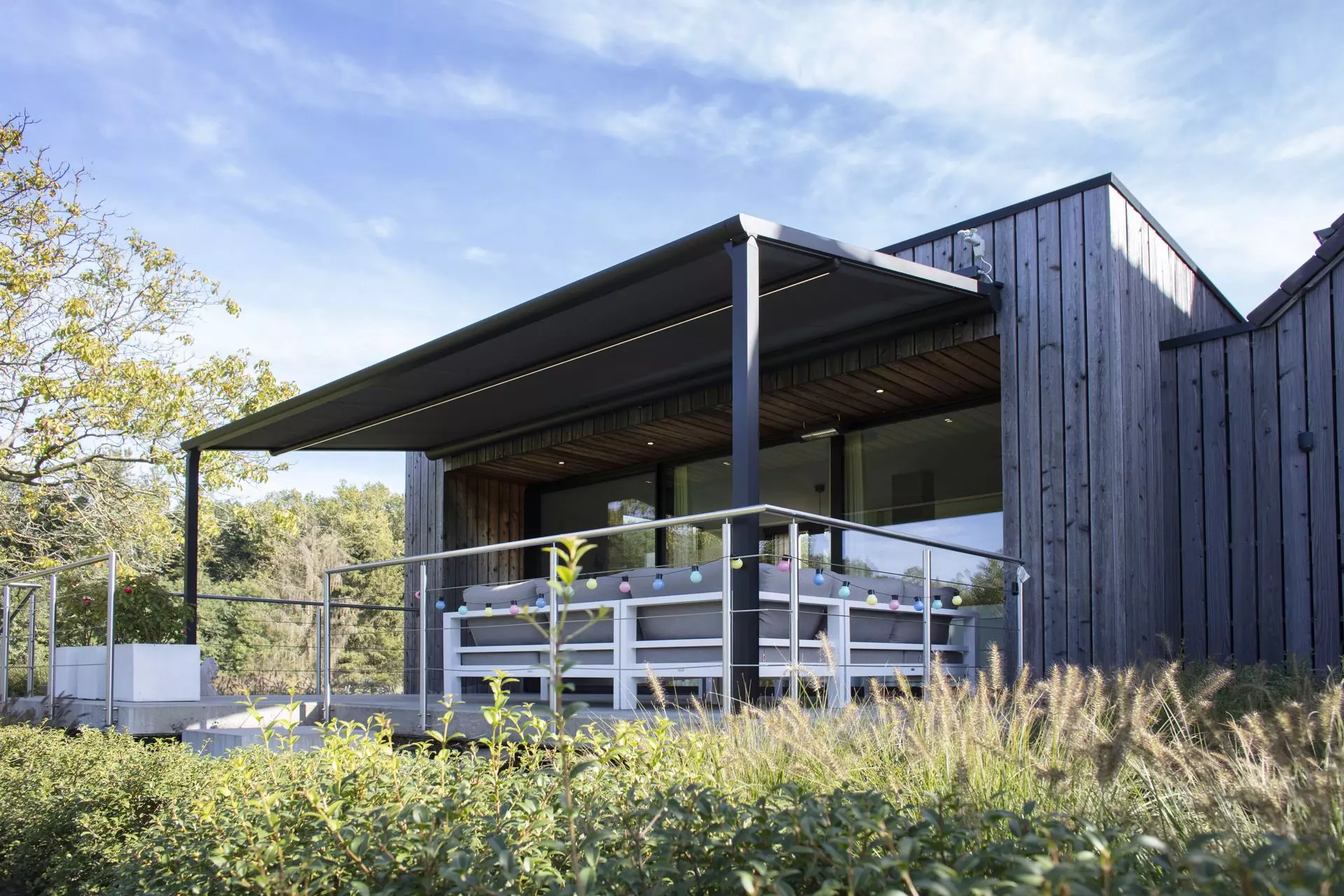 Pergola à toile Brustor B128 devant une façade en bois