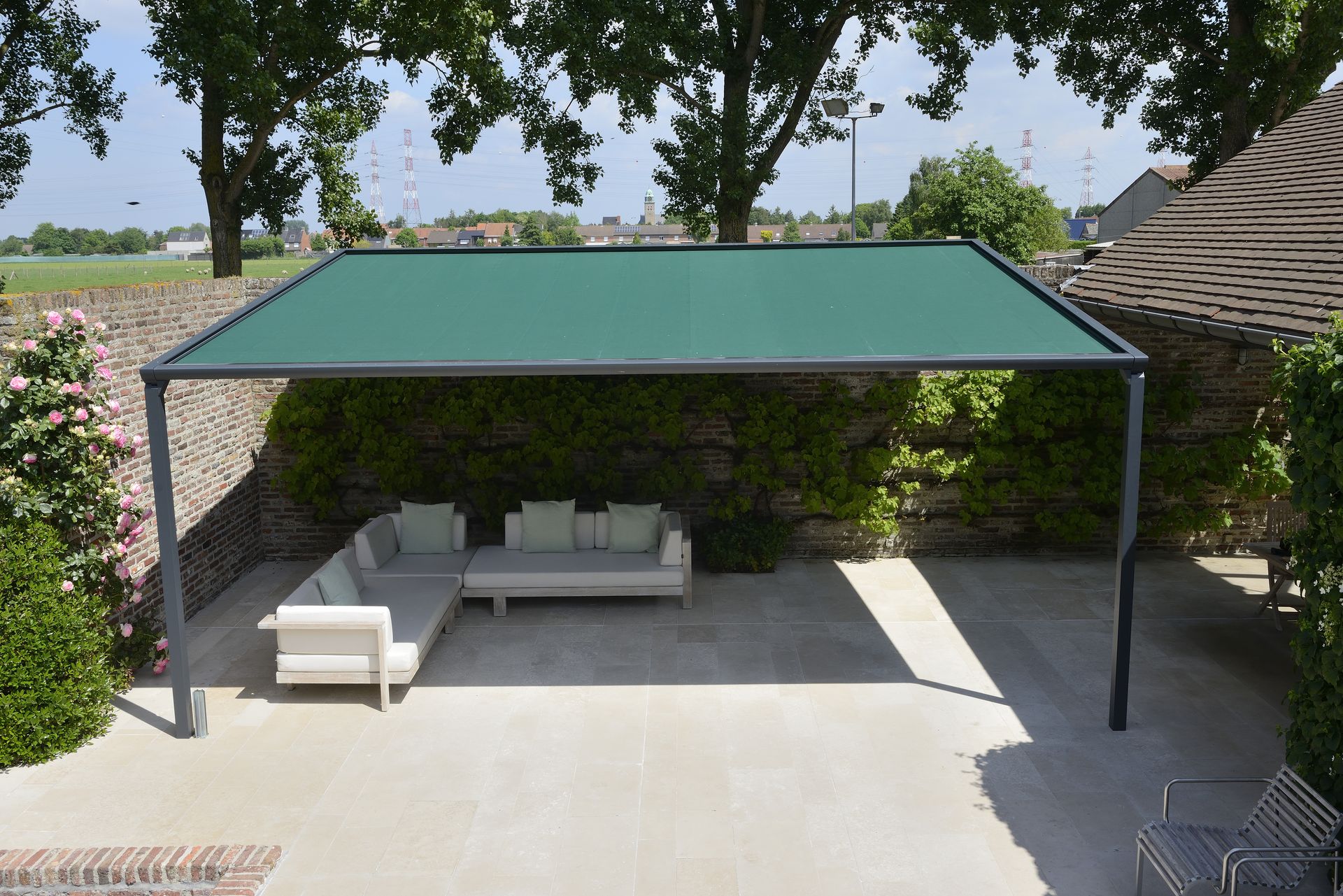 Pergola Brustor B128 avec toile verte vue en plongée sur un salon lounge