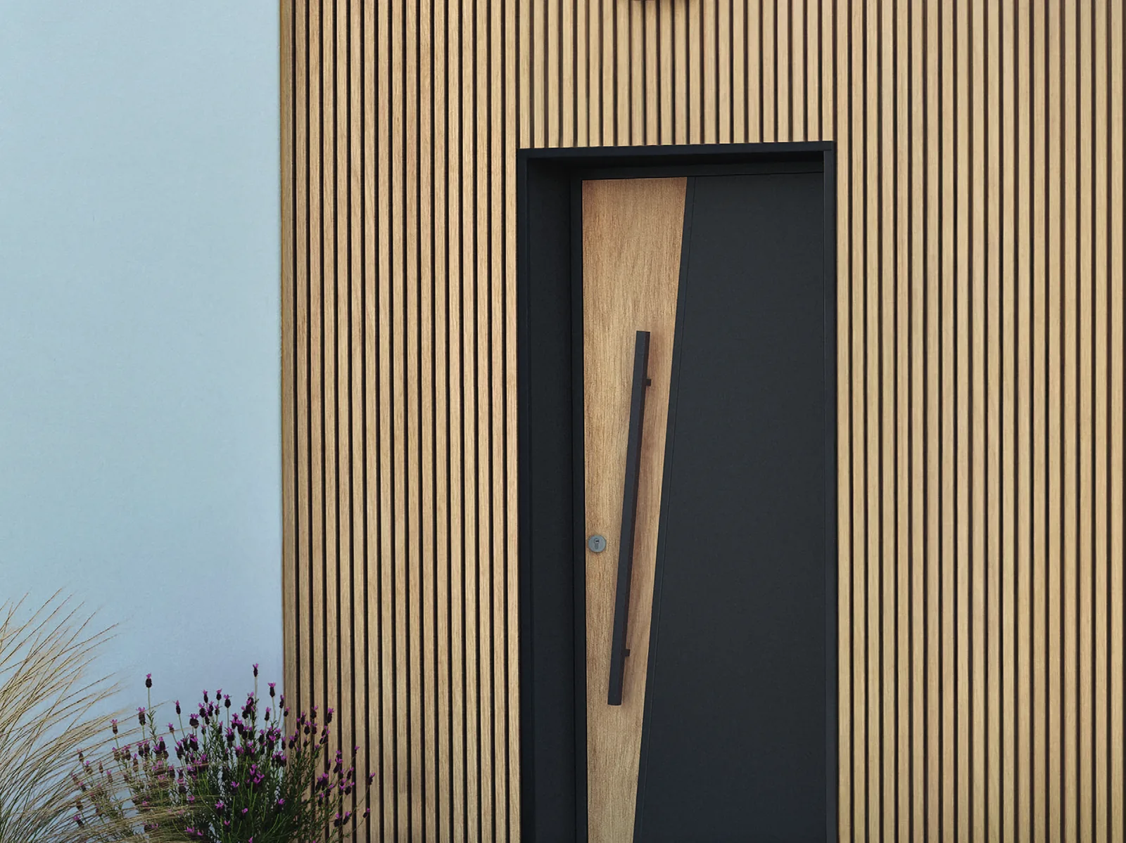 Porte d’entrée aluminium anthracite K-Line sur un bardage bois
