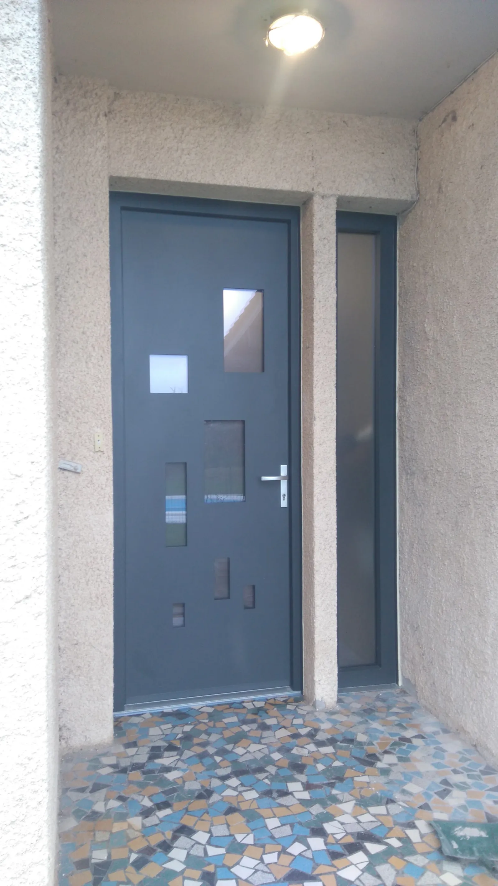 Porte d’entrée gris anthracite avec petits vitrages carrés