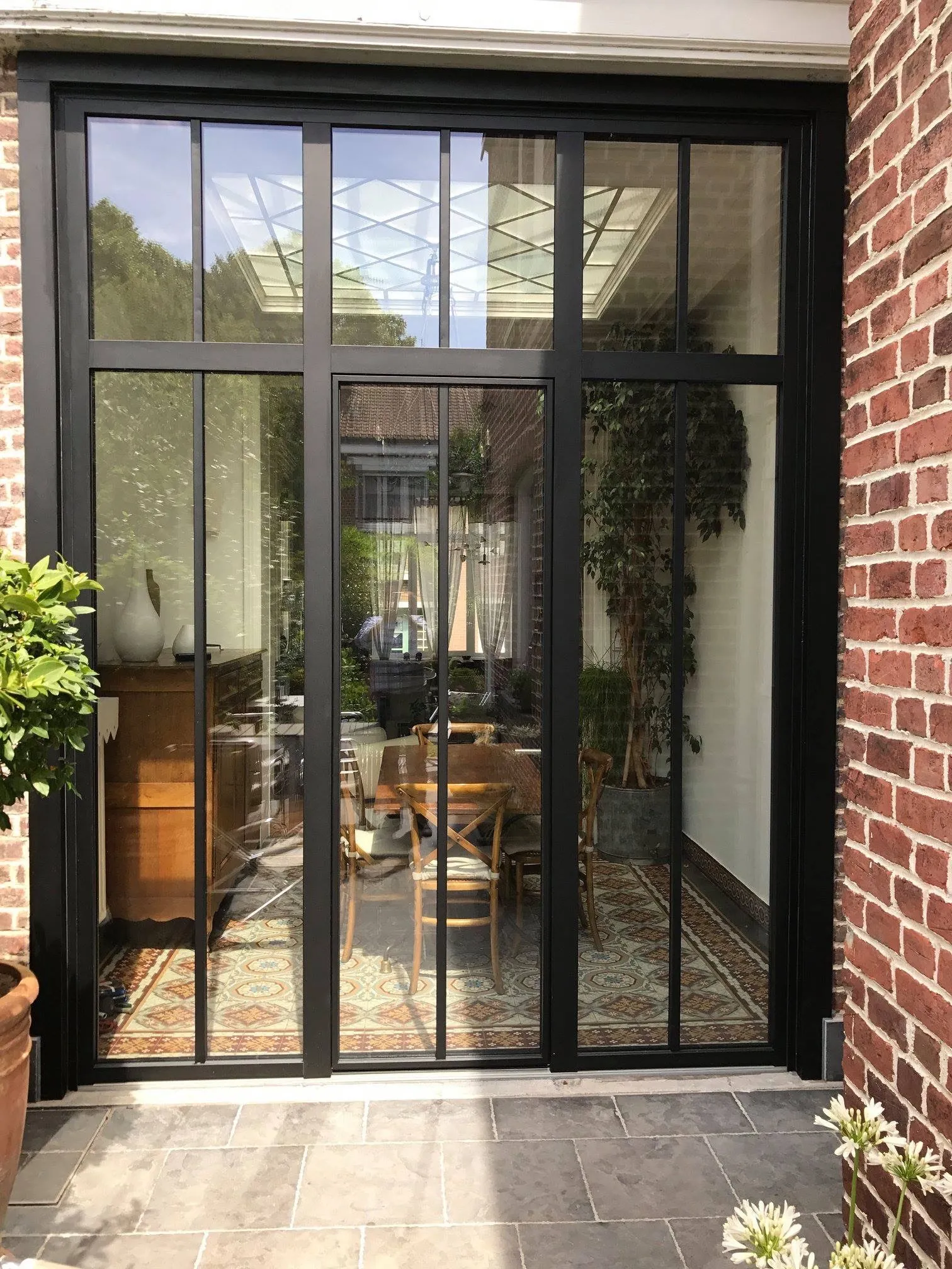 Porte-fenêtre style atelier à cadre noir ouvrant sur une pièce