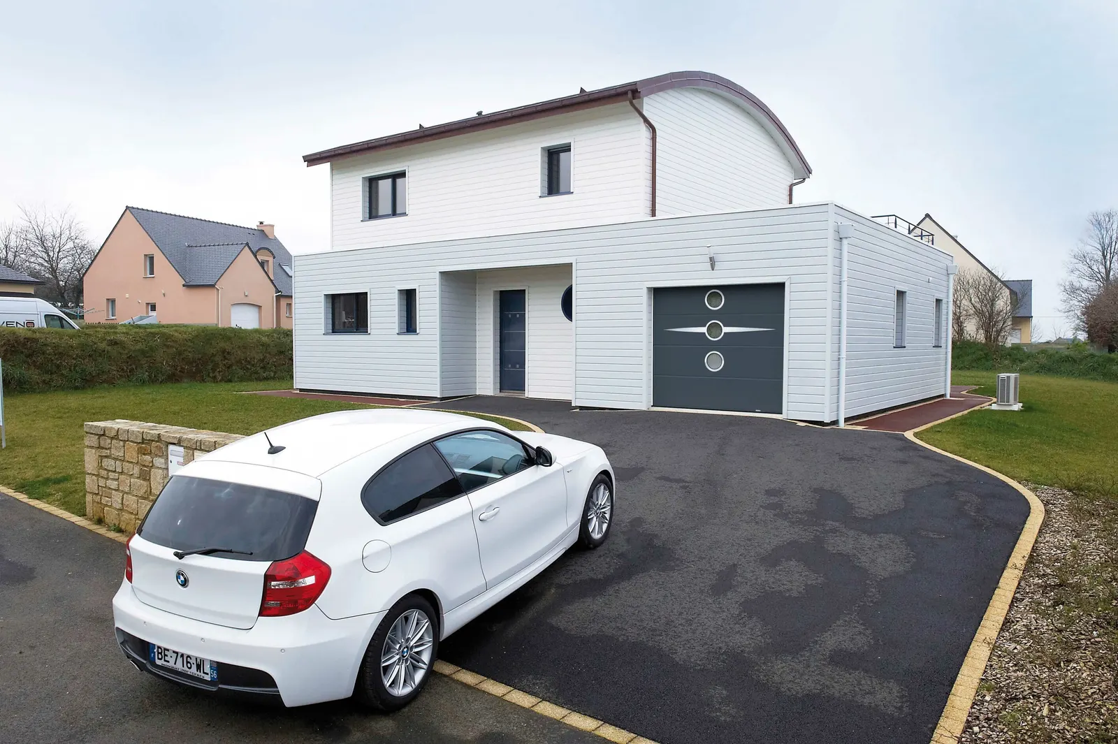 Porte de garage sectionnelle blanche à hublot rond