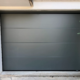 Porte de garage sectionnelle grise à rainures horizontales