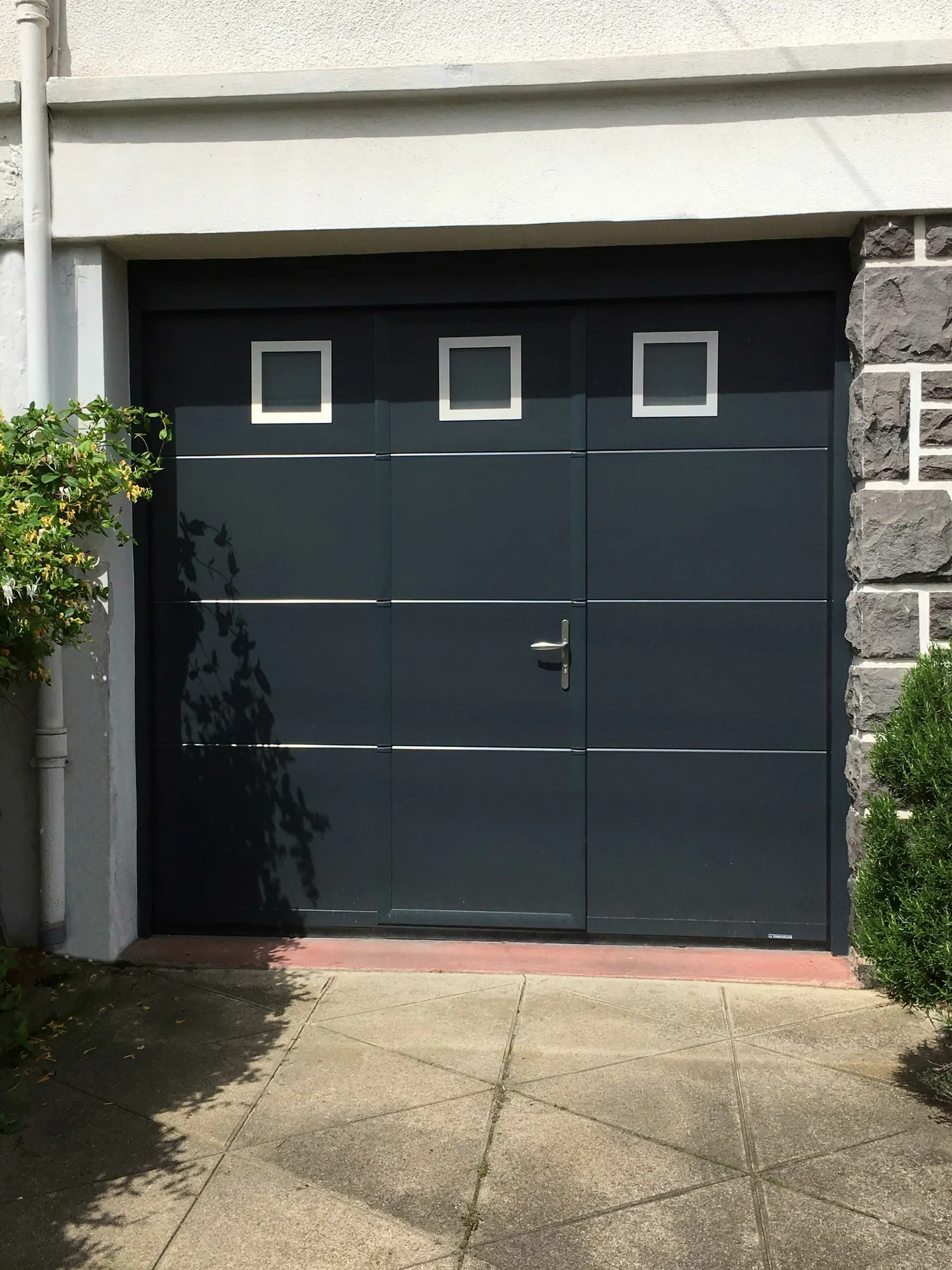 Porte de garage sectionnelle anthracite avec portillon et hublots