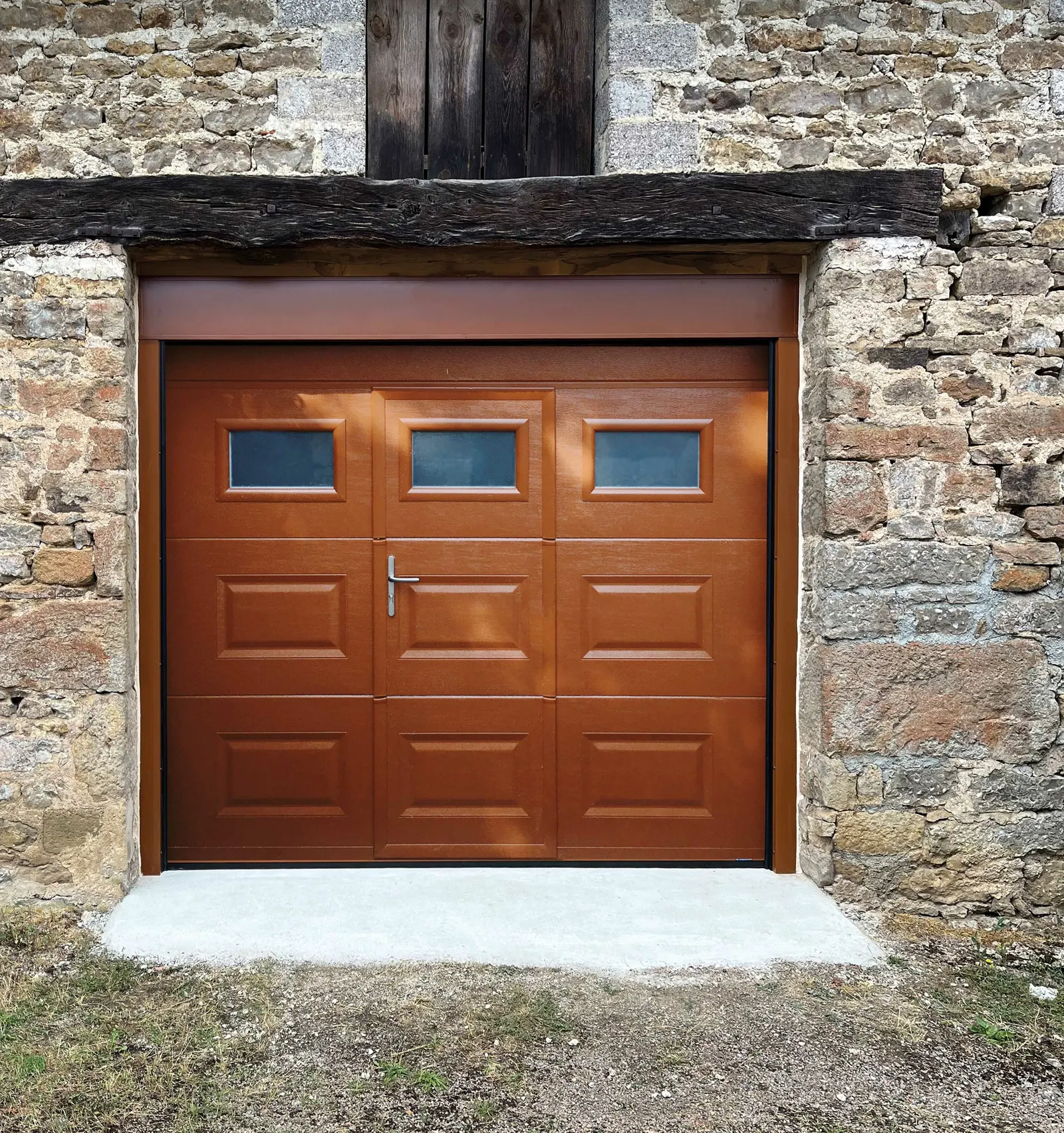 Porte de garage sectionnelle aspect bois avec portillon et hublots
