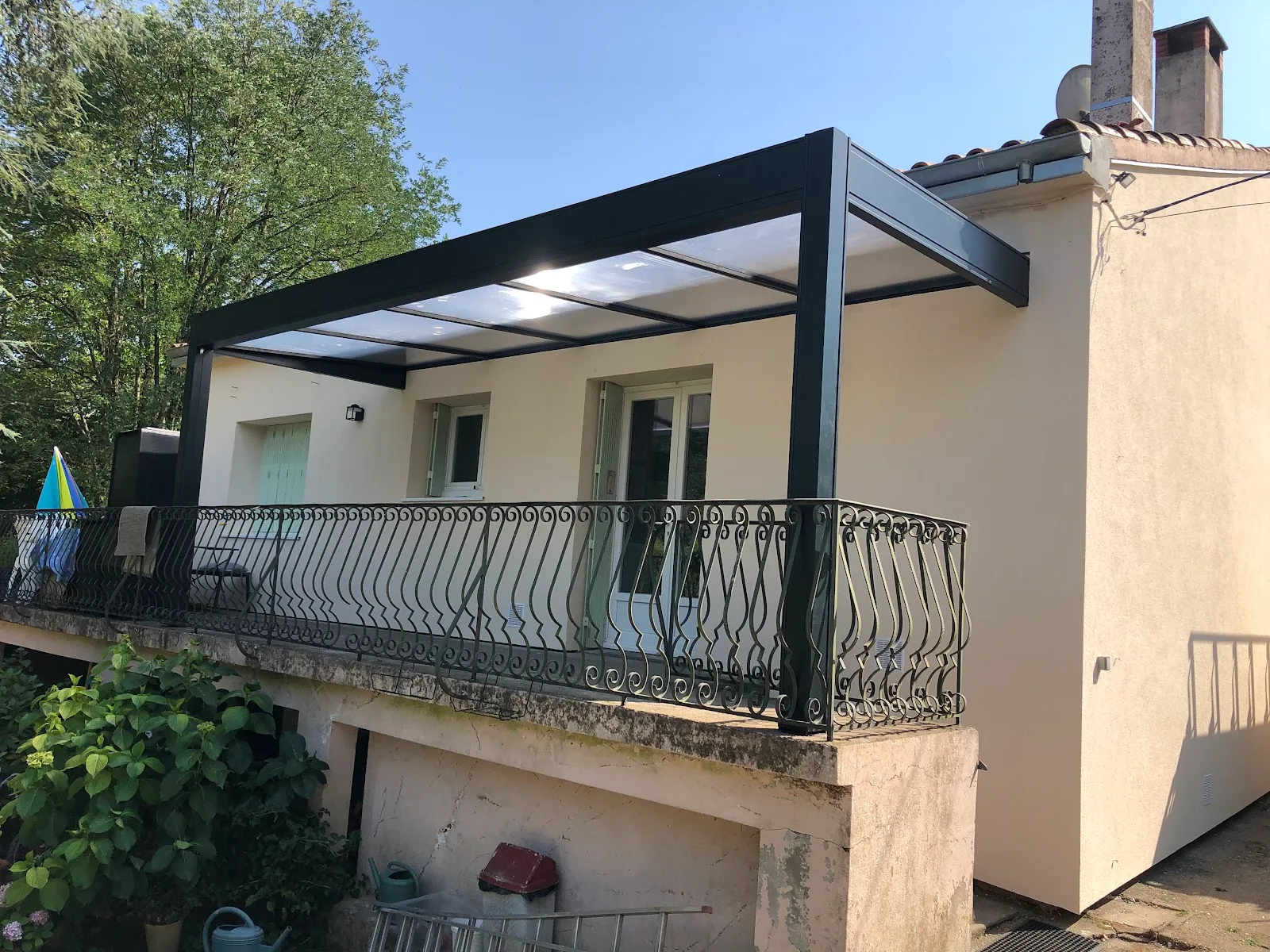 Préau en aluminium couvrant une terrasse surélevée