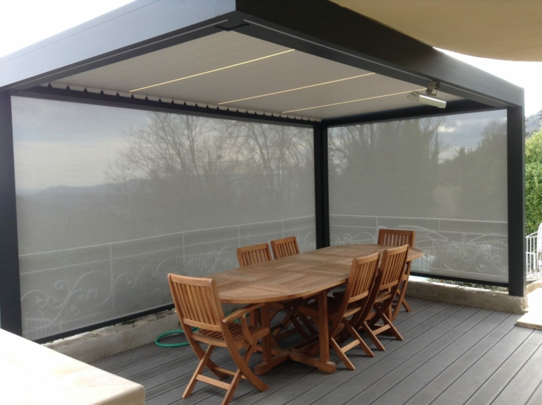 Coin repas sous pergola fermée par des screens