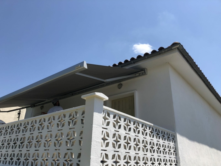 Store banne au-dessus d'un balcon à claustra