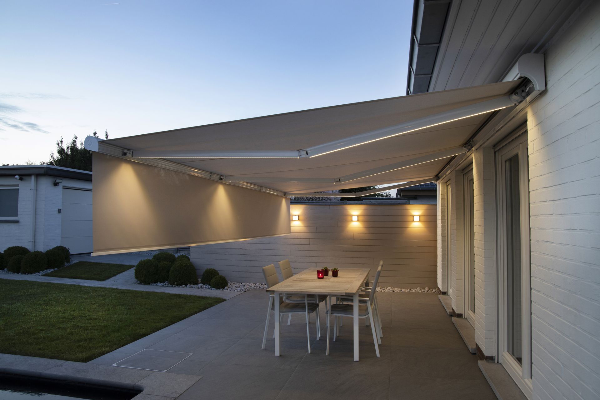 Store banne Brustor B25 avec volant et éclairage LED en soirée